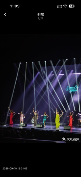 Performers on the Bay Opera stage beneath white and purple spotlights