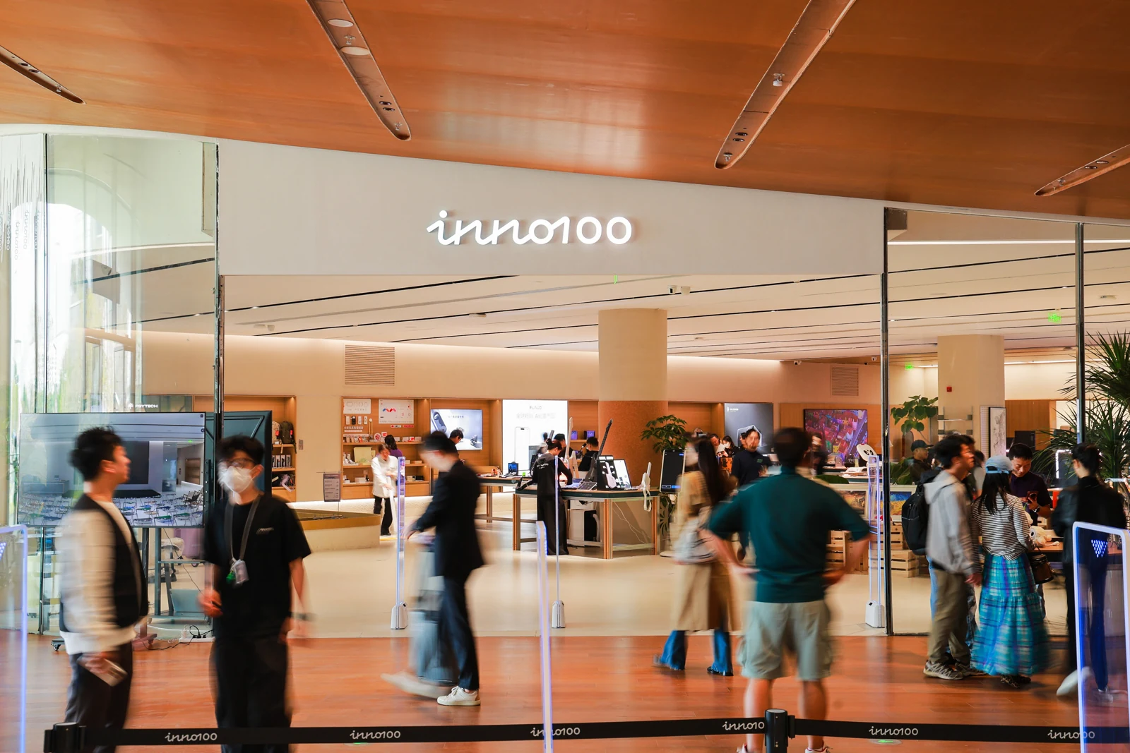 INNO100 entrance with its illuminated sign and visitors exploring the store