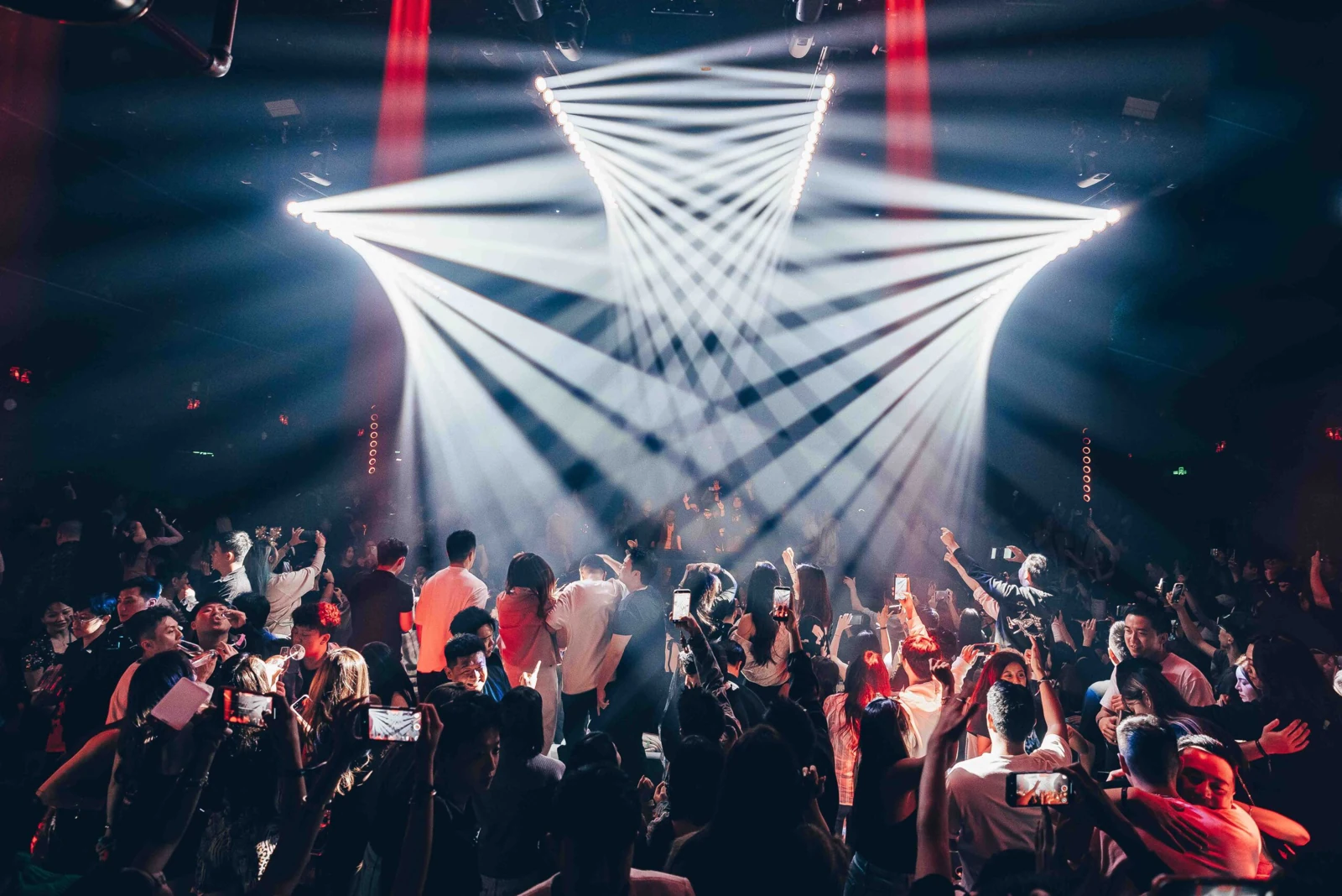 PLAY X main dance floor with guests beneath white geometric stage lighting
